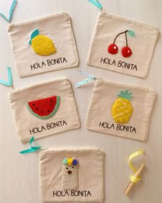 four embroidered pouches with fruits and vegetables on them