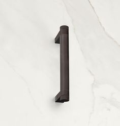 a close up of a door handle on a white marble wall with a black finish