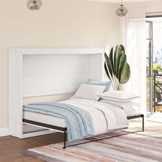 a bed with white sheets and pillows in a room next to a large potted plant