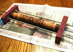 a wooden and metal contraption sitting on top of a table next to a newspaper