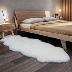 a bed with white sheepskin rug on the floor next to a night stand and mirror