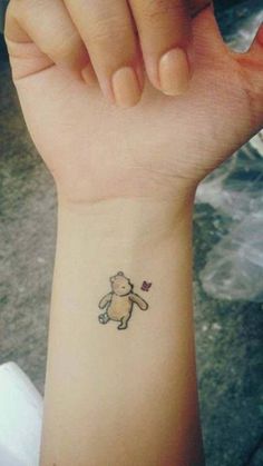 a small bear tattoo on the wrist