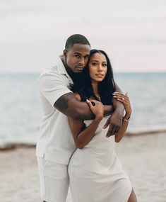 a man and woman hugging on the beach