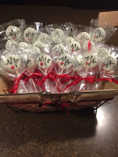 a basket filled with lots of white chocolate covered in red ribbon and wrapped in cellophane