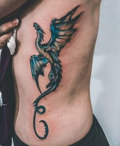 a woman's stomach with a dragon tattoo on her side and the bottom part of her body