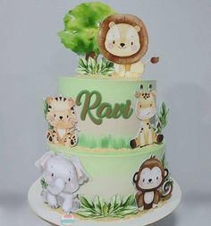 a three tiered cake with jungle animals on it and the word raw written in green