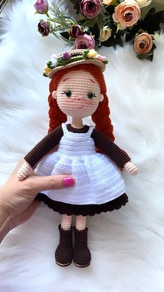 a crocheted doll wearing a white dress and brown shoes with a crown on her head