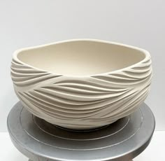 a white bowl sitting on top of a metal stand