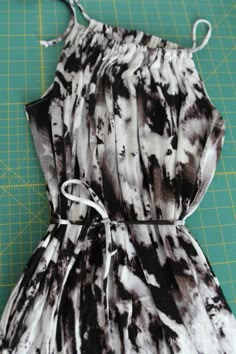 the back of a dress is being made on a cutting board with scissors and tape