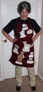 a woman standing in front of a white door wearing an apron with pictures on it