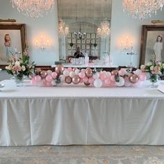 the table is set up with balloons, flowers and other decorations for an elegant party