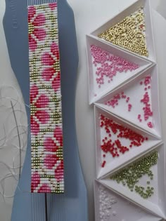 three pieces of beaded fabric sitting next to each other on top of a table