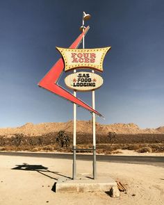 a sign in the middle of nowhere with mountains in the background