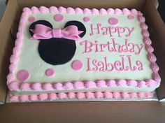 a pink and white birthday cake with minnie mouse on it's side in a box