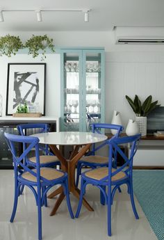 a dining room with blue chairs and a white table