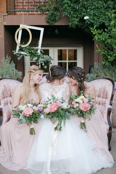 three bridesmaids sitting on an old chair with flowers in their hair and dresses