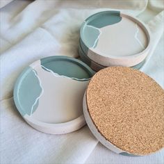 three plates with corked lids sitting on a white cloth