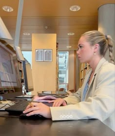 a woman sitting at a desk using a computer