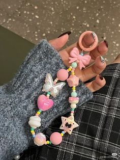 a hand holding a necklace with beads and charms on it's thumbnails