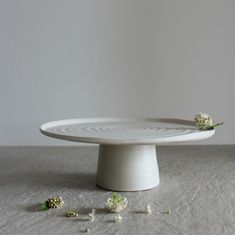 a white cake plate sitting on top of a table