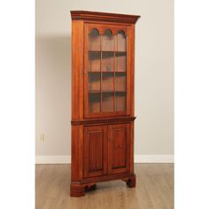 an old wooden china cabinet with glass doors on the top and bottom shelves, in a room