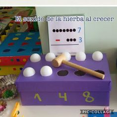 a purple box filled with white balls and a wooden baseball bat on top of it