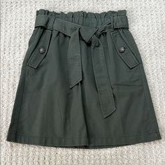 Nwt Loft | 100% Cotton Olive Green Belted Mini Skirt | Size 0 + Side Pockets With Decorative Button Detail + Sash Tie Belt + Paperbag Style Stretchy Waist + 100% Cotton Material, Feels Really Nice + Cool Olive Green Color + Mini Length + Perfect Condition Approximate Flat Measurements + Waist 13" + Length 19" Offers Welcome Belted Mini Skirt, Olive Green Color, Tie Belt, Button Detail, Green Color, Cotton Material, Olive Green, Mini Skirt, Really Cool Stuff