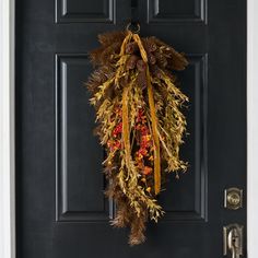 a black door with a wreath hanging on it