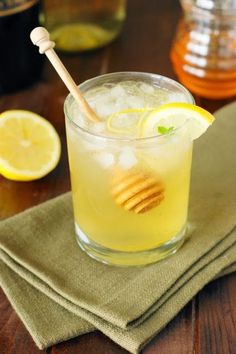 a glass filled with lemonade and honey on top of a table