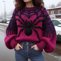 a woman wearing a pink and black spider sweater