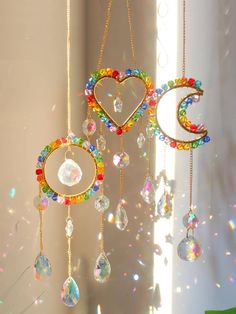 three wind chimes hanging from the ceiling with beads and crystals attached to each other