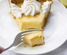 a piece of pie on a white plate with a fork in front of the slice