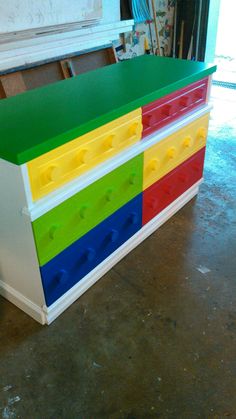 a multicolored chest of drawers sitting on top of a floor