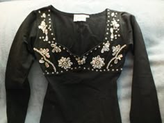 Tight fitting  black stretch long sleeve top. Designer Hunza. 90% cotton, 10% With beautiful crystal, pearl and sequin embellishment. Although the label says S/M it does fit tight so more like a Small. Fitted Long Sleeve Tops With Sequins, Elegant Long Sleeve Tops With Rhinestones, Stretch Evening Tops With Rhinestones, Elegant Winter Tops With Rhinestones, Elegant Rhinestone Tops For Winter, Elegant Rhinestone Tops, Fitted Rhinestone Tops For Fall, Glamorous Long Sleeve Tops With Rhinestones, Whimsigoth Tops