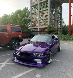 a purple car parked in front of a red truck