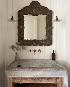 a bathroom sink with a mirror above it and two lights hanging from the wall behind it