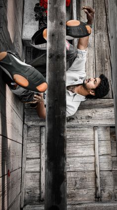 a man standing on top of a wooden floor next to another person with their feet in the air