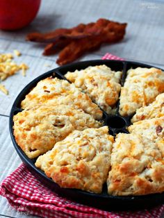 an apple and bacon biscuit cake in a pan on a red checkered cloth