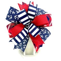 a red, white and blue bow with anchors on the side is sitting in a vase