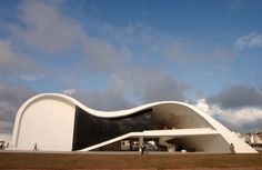 a large white building sitting on top of a lush green field