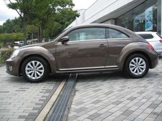 a brown car parked in front of a building