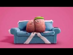 two stuffed toys sitting on top of a blue couch next to each other in front of a pink background