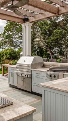 an outdoor kitchen with grill and seating area