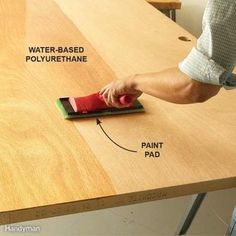 a person using a sponge to clean a wooden table