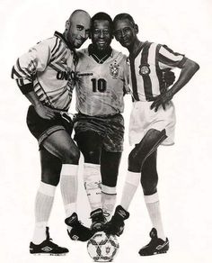 three men standing next to each other near a soccer ball