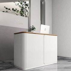 a white cabinet sitting on top of a marble floor next to a mirror and plant