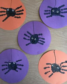 four paper plates with handprints on them and one has a spider in the middle