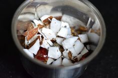 a blender filled with sugar and cubes on top of a black countertop