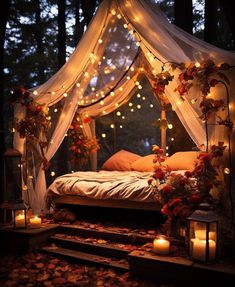 a canopy bed with lights strung over it and some flowers on the ground next to it