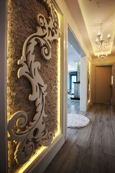 a hallway with wood floors and lights on the wall, along with a rug that looks like a dog bed